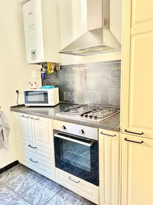 a kitchen with white cabinets and a stove top oven at Casa Camilla in Rome