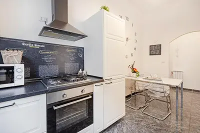 a kitchen with white cabinets and a counter top at Casa Camilla in Rome