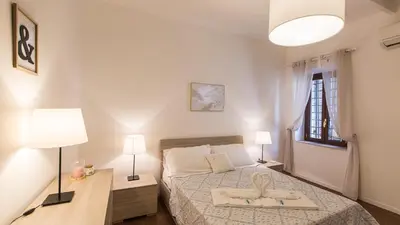 a bedroom with a bed and two lamps and a window at Rental in Rome Pelliccia in Rome