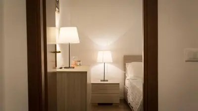 a bedroom with a bed and two lamps on a night stand at Rental in Rome Pelliccia in Rome
