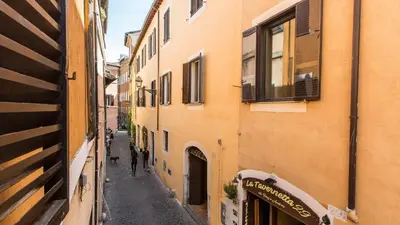 a person walking down an alley between two buildings at Rental in Rome Pelliccia in Rome