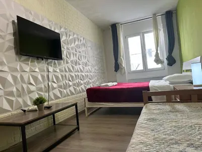 a room with two beds and a tv on the wall at Kobe's Apartment in Rome