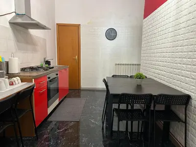 a kitchen with red cabinets and a table with chairs at Kobe's Apartment in Rome