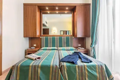 a bedroom with a bed with a mirror above it at Raeli Hotel Floridia in Rome