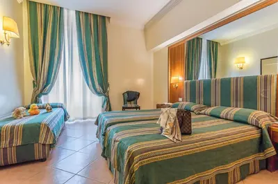 a hotel room with two beds and a window at Raeli Hotel Floridia in Rome