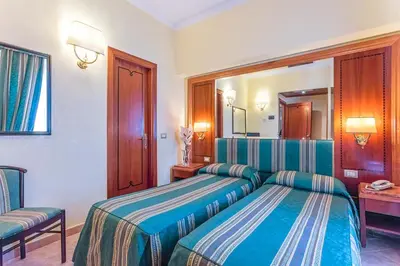 a hotel room with two beds and a mirror at Raeli Hotel Floridia in Rome