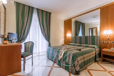 a hotel room with a bed and a desk at Raeli Hotel Regio in Rome