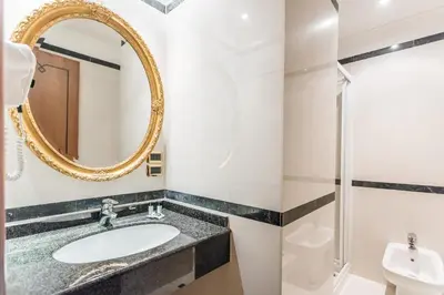 a bathroom with a sink and a mirror at Raeli Hotel Regio in Rome