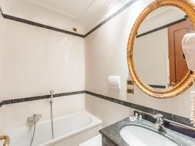 a bathroom with a sink and a mirror at Raeli Hotel Regio in Rome