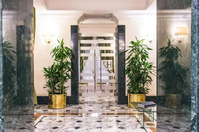 a lobby with potted plants in front of a door at Raeli Hotel Regio in Rome