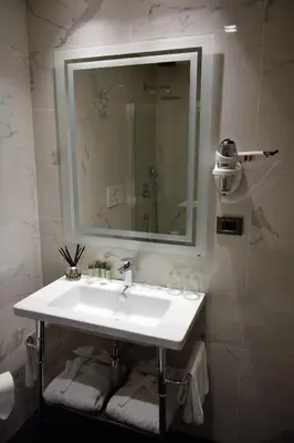 a bathroom with a white sink and a mirror at Raeli Hotel Archimede in Rome