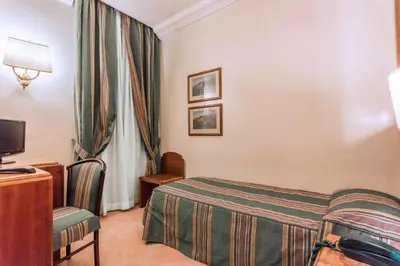 a hotel room with a bed and a tv at Raeli Hotel Archimede in Rome