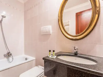 a bathroom with a sink and a mirror and a toilet at Raeli Hotel Archimede in Rome