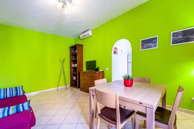 a dining room with green walls and a table and chairs at Apartment Angelo Emo 69 in Rome