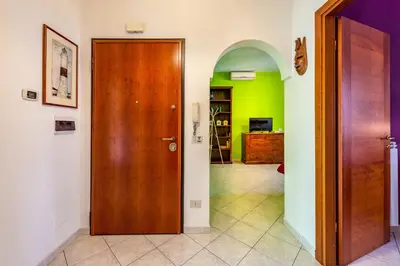 a hallway with a wooden door and green walls at Apartment Angelo Emo 69 in Rome