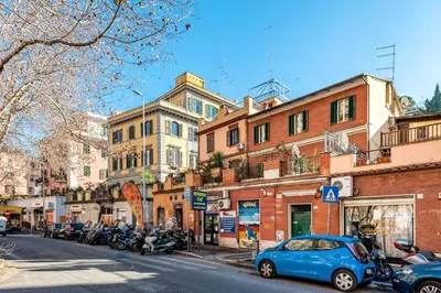 a blue car parked on a city street with buildings at Apartment Angelo Emo 69 in Rome