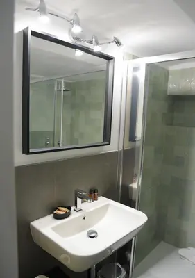 a bathroom with a sink and a shower with a mirror at Farnese 48 in Rome
