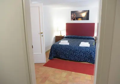 a bedroom with a bed and a red and blue comforter at Farnese 48 in Rome