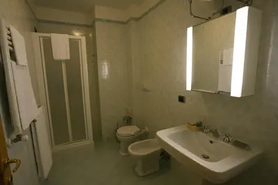 a white bathroom with a sink and a toilet at Lux Appartamenti in Rome