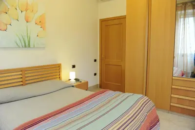 a bedroom with a bed and a painting on the wall at Lux Appartamenti in Rome
