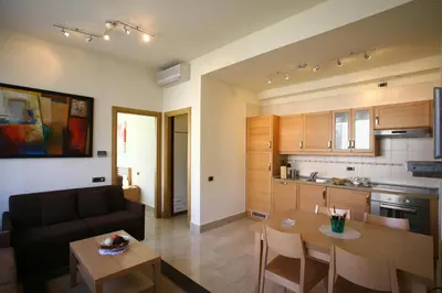 a kitchen and a living room with a couch and a table at Lux Appartamenti in Rome