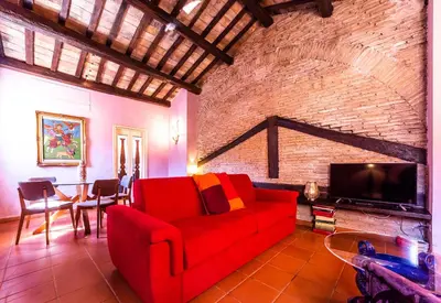 a living room with a red couch and a brick wall at maison specchi in Rome
