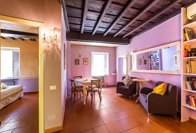 a living room with purple walls and a table and chairs at maison specchi in Rome