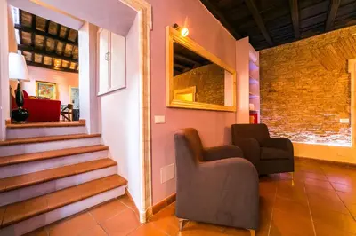 a living room with two chairs and a staircase at maison specchi in Rome