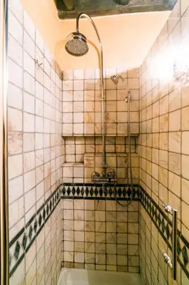 a tiled bathroom with a shower with a tub at maison specchi in Rome
