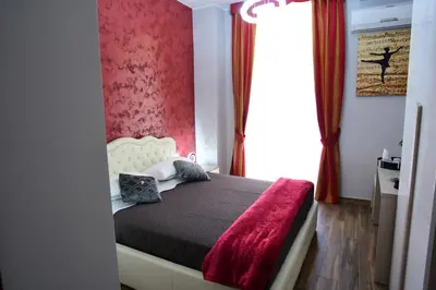 a bedroom with a bed with a red wall at Royal Termini in Rome