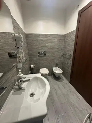 a bathroom with a white sink and a toilet at Royal Termini in Rome