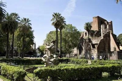 a statue in front of a building with palm trees at Royal Termini in Rome