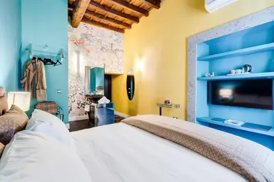 a bedroom with a large bed and a tv at The French suites by oneup Hospitality in Rome