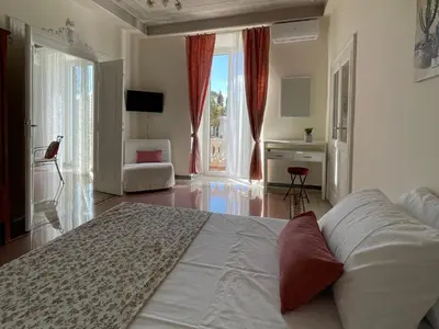 a bedroom with a large bed and a living room at Domus Claudia San Giovanni in Rome