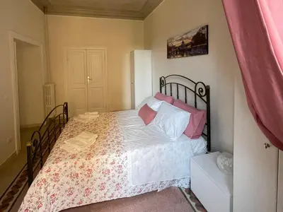 a bedroom with a bed with white and pink pillows at Domus Claudia San Giovanni in Rome