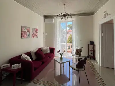 a living room with a red couch and a table at Domus Claudia San Giovanni in Rome