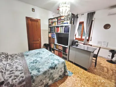 a bedroom with a bed and a book shelf with books at In the Heart of Rome in Rome
