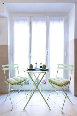 two chairs and a table in a room with windows at Marco Polo Vatican APARTMENT Metro A 2 min - San Pietro 10 min in Rome