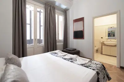 a bedroom with a large white bed and a bathroom at Dimora storica Palazzo Marescalchi Belli in Rome