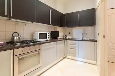 a kitchen with white cabinets and a microwave at Dimora storica Palazzo Marescalchi Belli in Rome