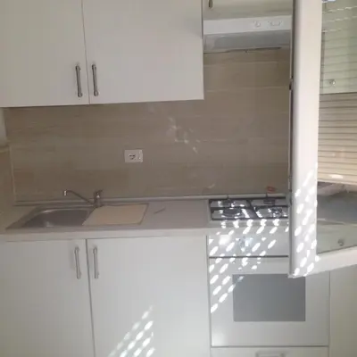 a kitchen with white cabinets and a sink at flaminio heart house in Rome