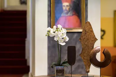 a table with a vase of flowers and a painting at Hotel S. Anna in Rome
