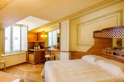 a bedroom with a large bed and a kitchen at Hotel S. Anna in Rome
