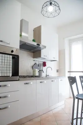 a white kitchen with white cabinets and a sink at Enjoy Porta Furba in Rome