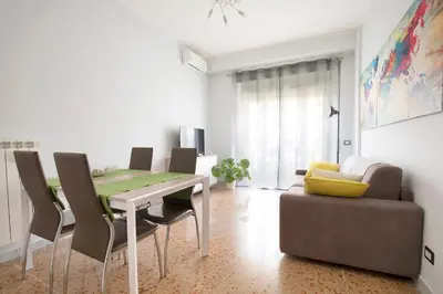 a dining room with a table and chairs and a couch at Enjoy Porta Furba in Rome