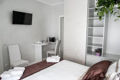 a bedroom with a bed and a tv and a chair at Il Magnificus Boutique in Rome