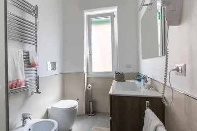 a bathroom with a sink and a toilet and a window at La Casa di Anto - San Giovanni in Rome