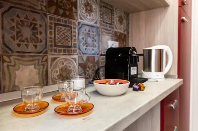 a counter with glasses and a coffee maker on it at La Casa di Anto - San Giovanni in Rome