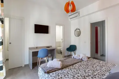 a bedroom with a bed and two chairs and a desk at La Casa di Anto - San Giovanni in Rome