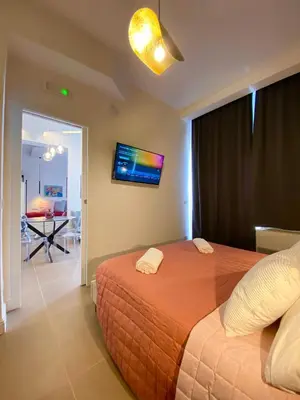 a bedroom with a bed and a tv on the wall at La Maison, vicino al Colosseo! in Rome